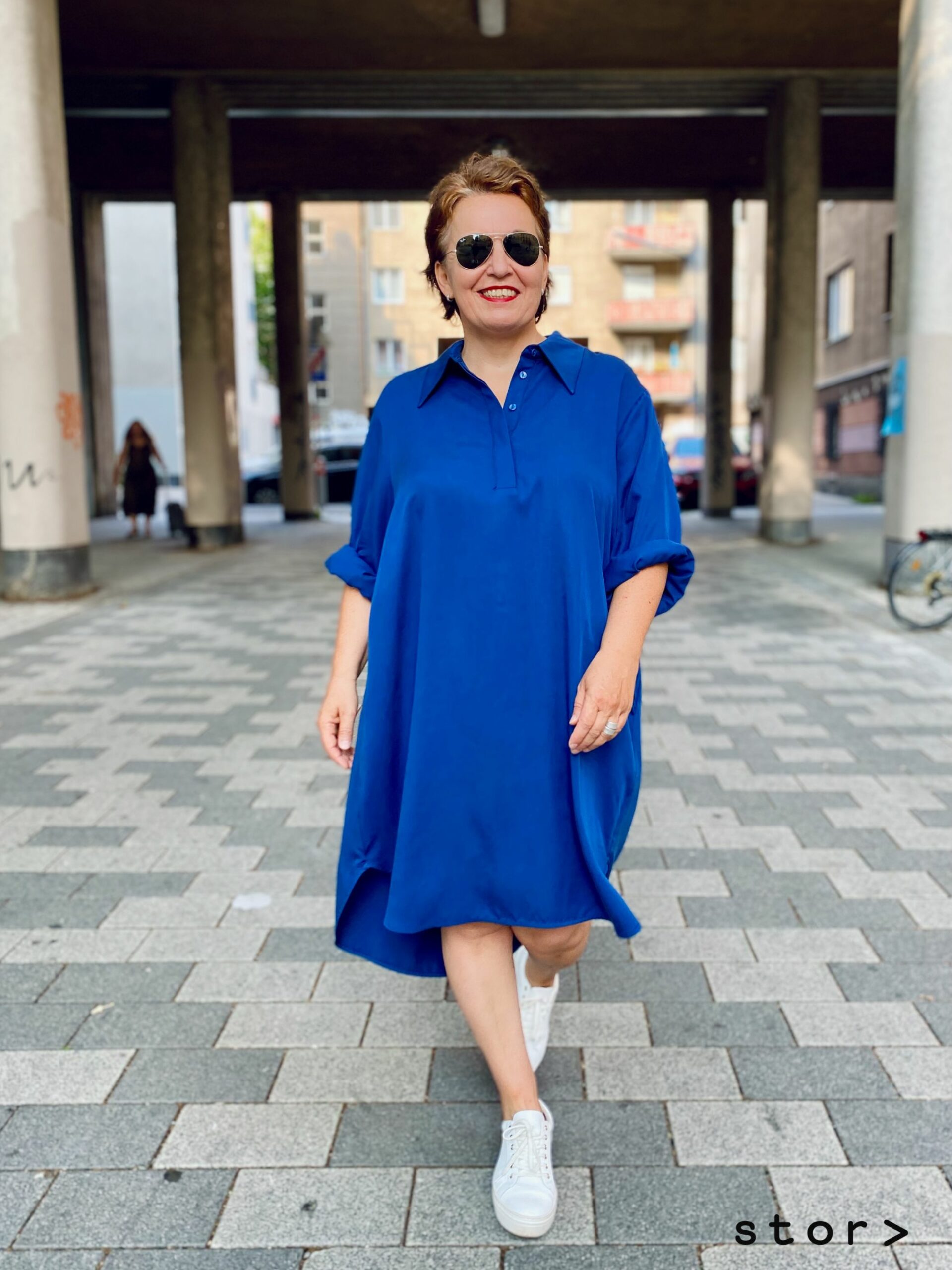 Modische Kleider in großen Größen sind bei stor in Wien Josefstadt erhältlich. Zu sehen ein blaues Kleid in lässig weiter Blusenform.